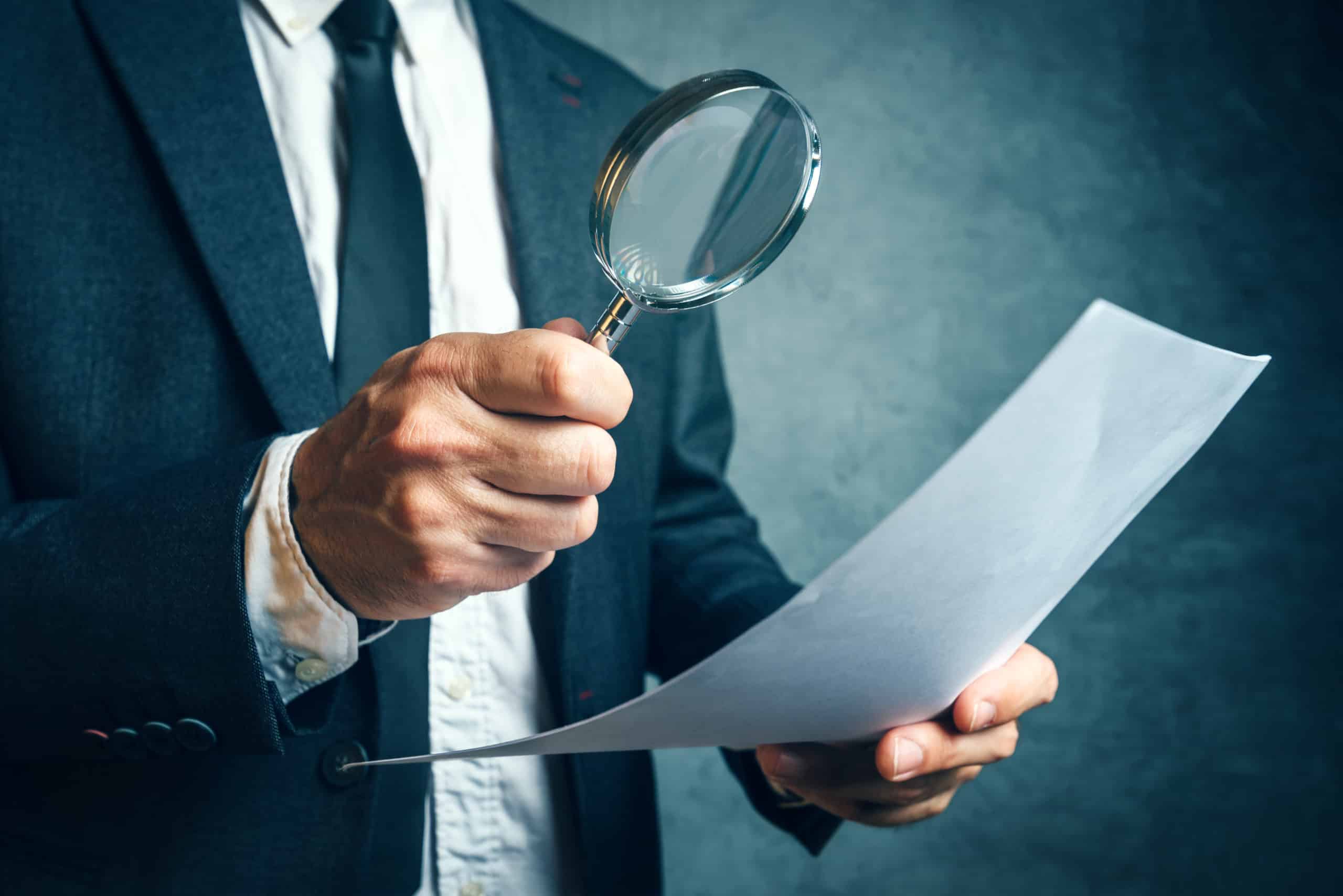 Tax inspector investigating financial documents through magnifyi